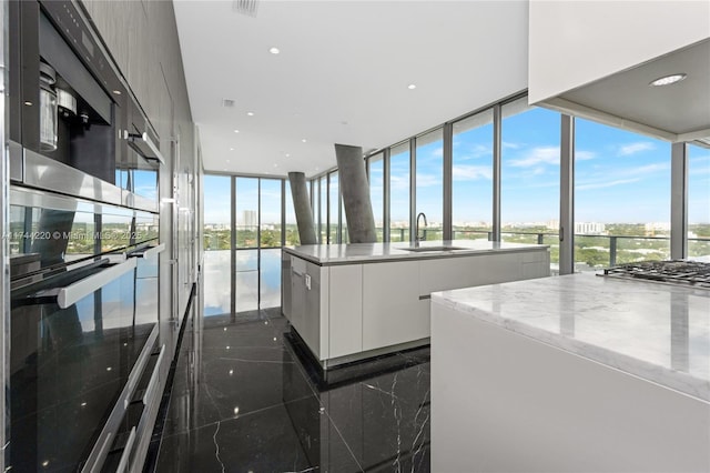 kitchen with a center island, sink, a wealth of natural light, and white cabinets