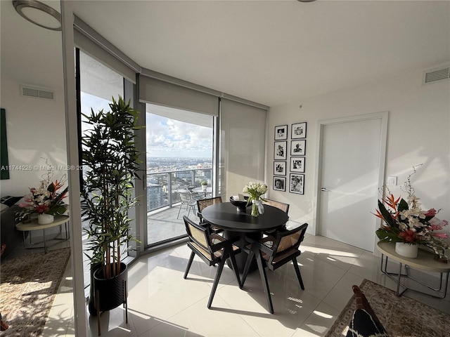 tiled dining area featuring floor to ceiling windows and visible vents