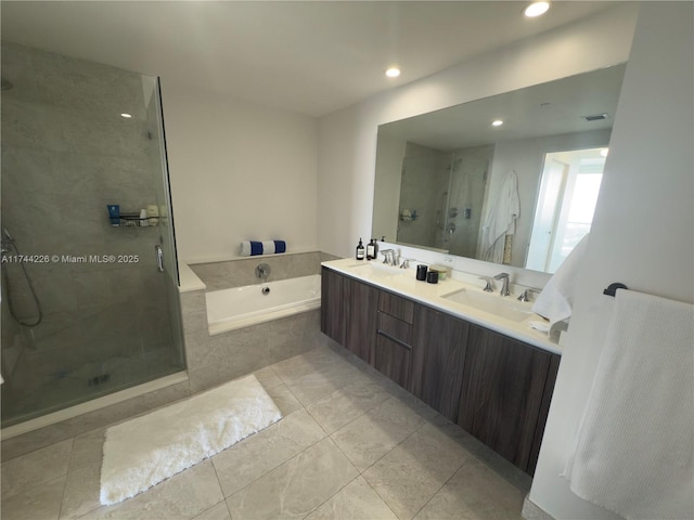 full bathroom featuring double vanity, visible vents, a sink, a shower stall, and a bath