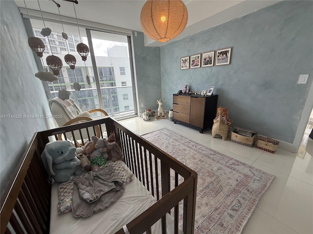 bedroom featuring access to exterior, tile patterned flooring, and a wall of windows