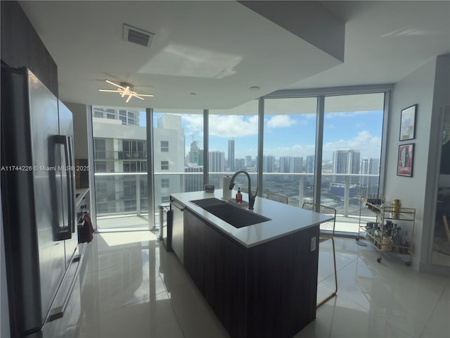 kitchen with a city view, freestanding refrigerator, a sink, modern cabinets, and a wall of windows