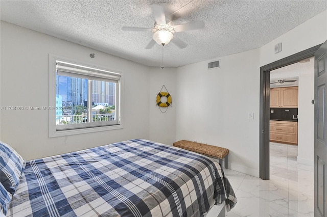 bedroom featuring ceiling fan and a textured ceiling