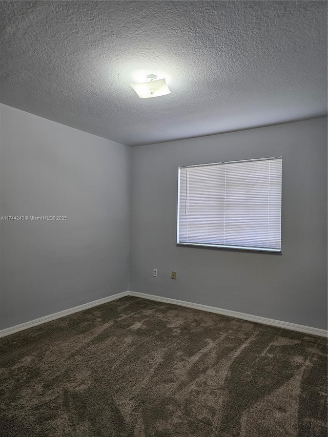 carpeted empty room with a textured ceiling