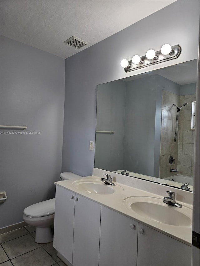 full bathroom featuring vanity, a textured ceiling, tile patterned floors, toilet, and tiled shower / bath