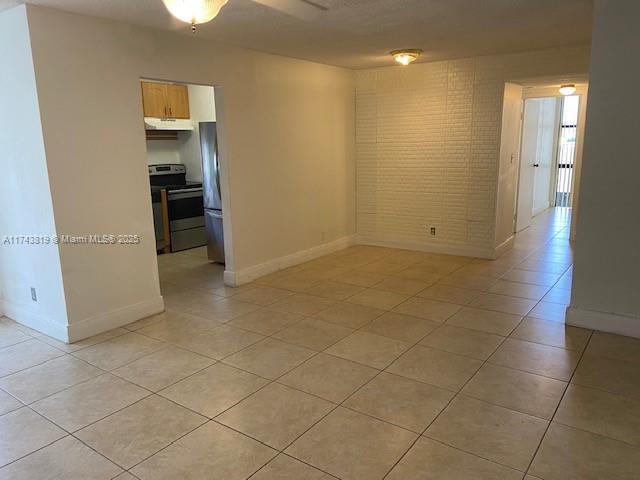 tiled empty room with brick wall