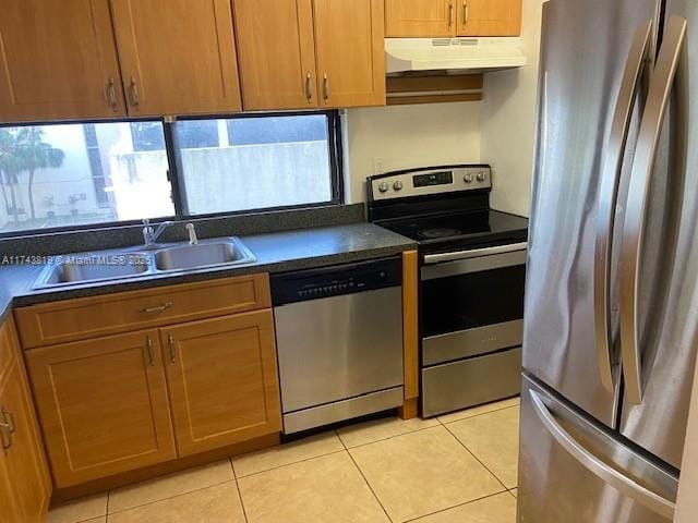 kitchen with appliances with stainless steel finishes, sink, and light tile patterned floors