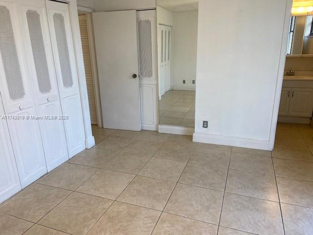 unfurnished bedroom featuring sink and light tile patterned floors