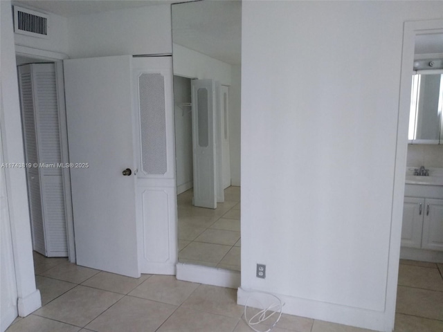 unfurnished bedroom with sink and light tile patterned floors