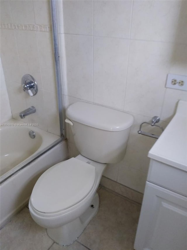 full bathroom featuring tiled shower / bath, vanity, toilet, and tile patterned flooring