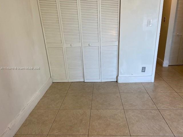 unfurnished bedroom featuring a closet and light tile patterned floors