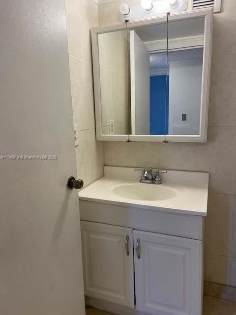 bathroom with vanity and tile walls