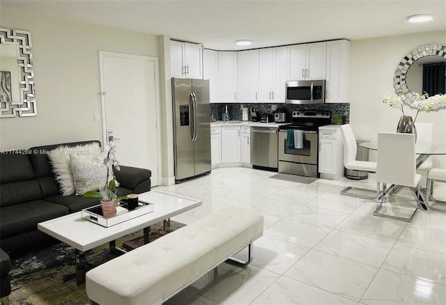 kitchen featuring white cabinetry, appliances with stainless steel finishes, and decorative backsplash