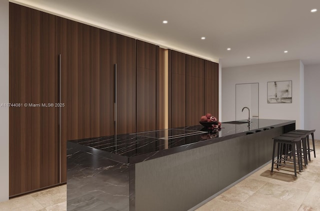 kitchen with dark brown cabinets, sink, a breakfast bar area, and kitchen peninsula