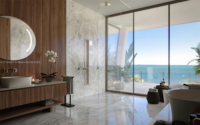 bathroom featuring a water view, vanity, a washtub, and expansive windows