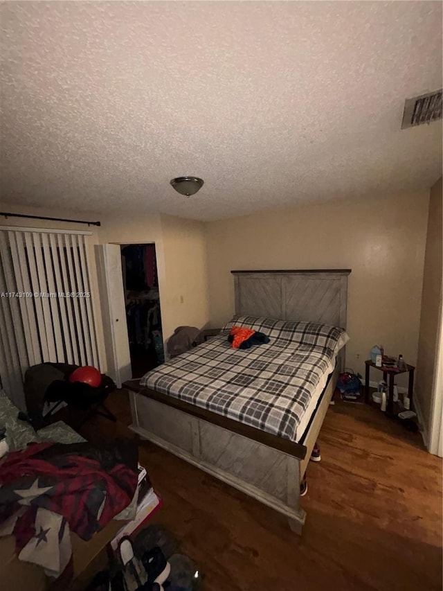 bedroom featuring dark hardwood / wood-style floors and a textured ceiling