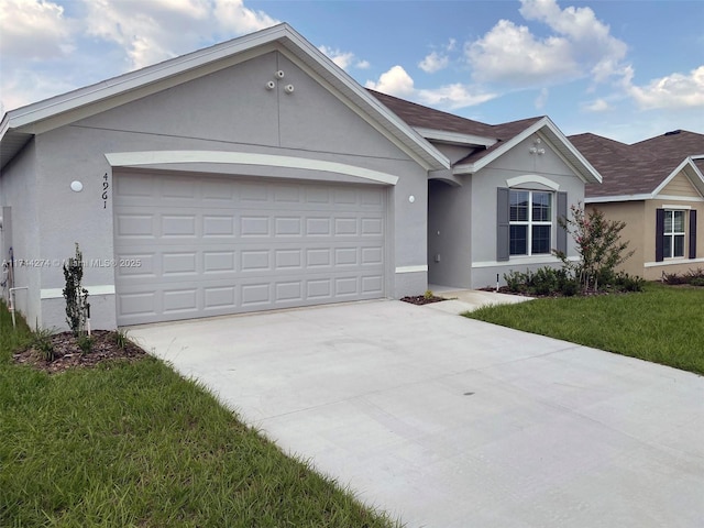 ranch-style house with a garage and a front lawn