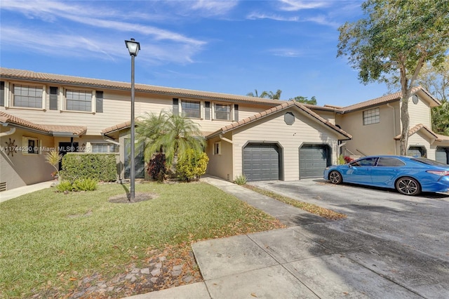 view of property with a garage and a front lawn