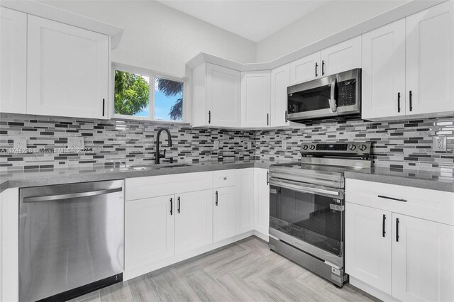 kitchen featuring stainless steel dishwasher, white cabinets, and kitchen peninsula