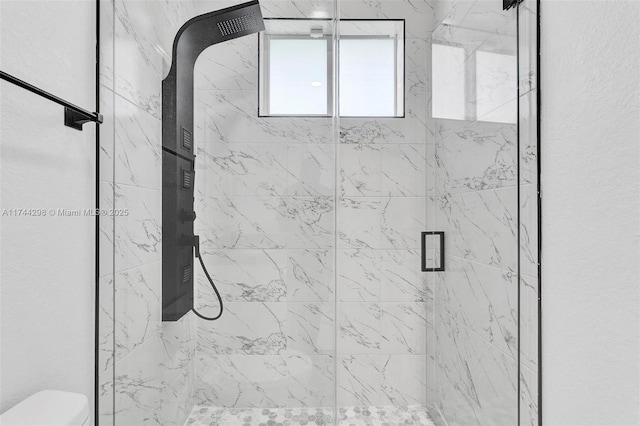 bathroom with a shower with door and toilet