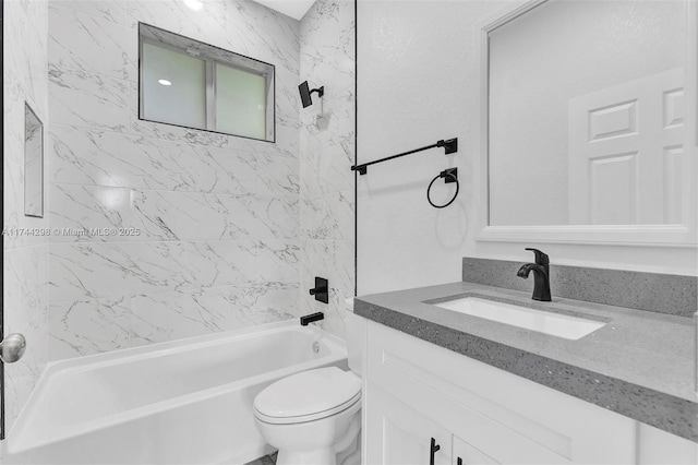 full bathroom featuring tiled shower / bath, vanity, and toilet