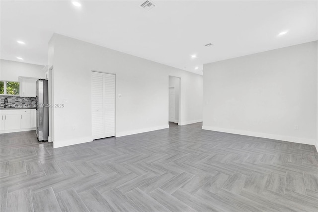 spare room featuring sink and light parquet flooring