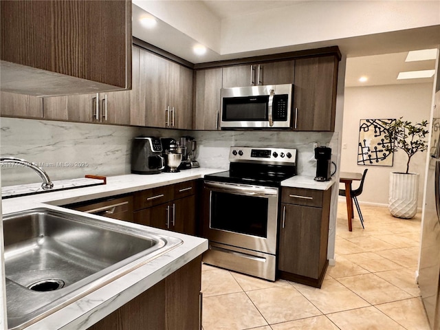 109 Heatherbrook Way Unit 146, Hollywood, FL 33021 - kitchen with light countertops, appliances with stainless steel finishes, decorative backsplash, and dark brown cabinetry