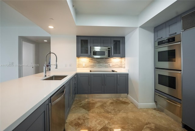 kitchen featuring tasteful backsplash, stainless steel appliances, and sink