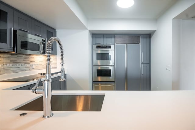 kitchen featuring stainless steel appliances, sink, and decorative backsplash