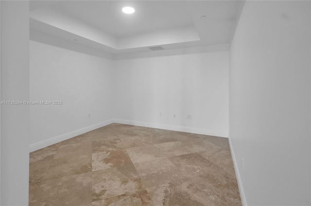 unfurnished room with a raised ceiling