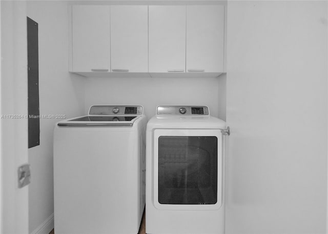 washroom with cabinets and washing machine and clothes dryer