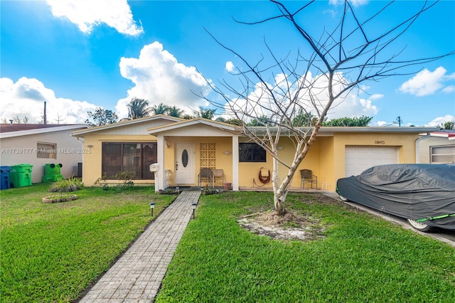 single story home featuring a garage, a front yard, and stucco siding