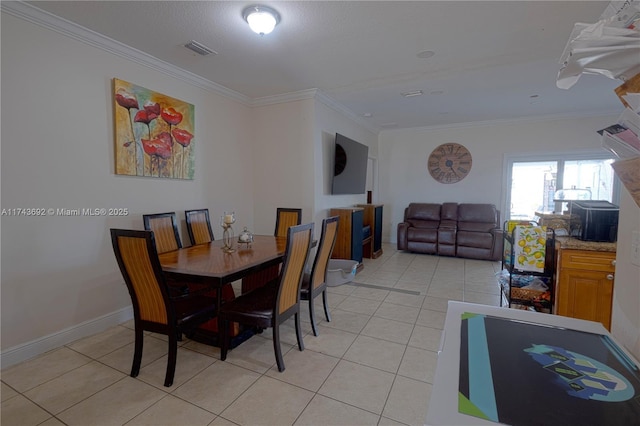 dining room with crown molding and light tile patterned floors