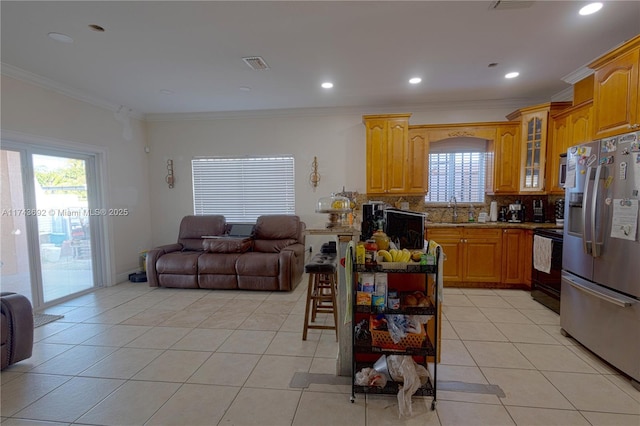 kitchen featuring sink, stainless steel fridge with ice dispenser, black electric range, light tile patterned floors, and ornamental molding