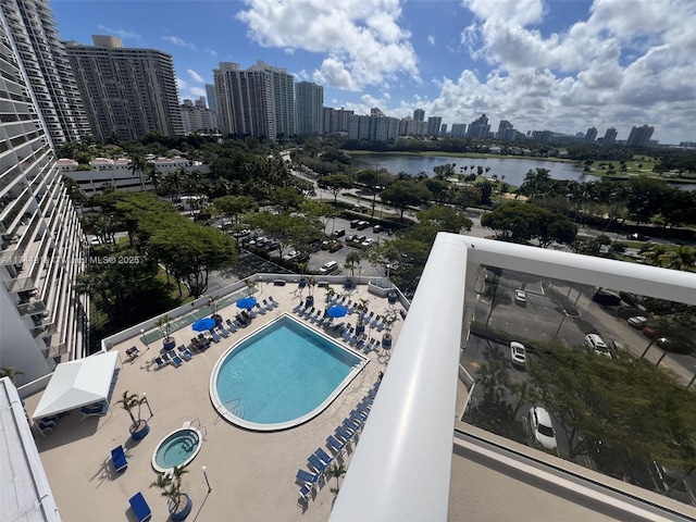 view of pool featuring a water view and a hot tub