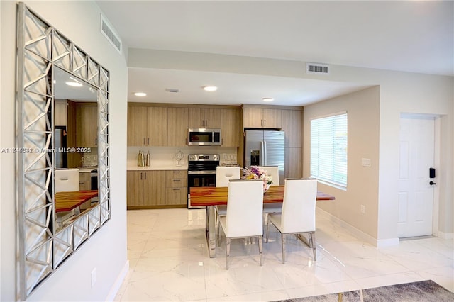 kitchen featuring stainless steel appliances, wooden counters, and a kitchen bar