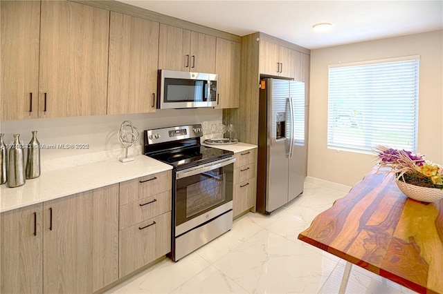 kitchen with light brown cabinetry and stainless steel appliances