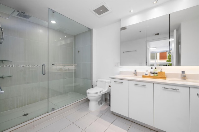 bathroom with vanity, a shower with shower door, tile patterned floors, and toilet