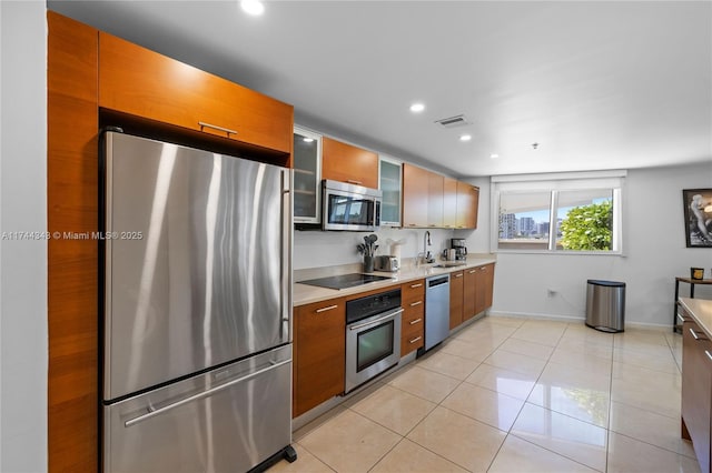kitchen with light tile patterned flooring, stainless steel appliances, and sink