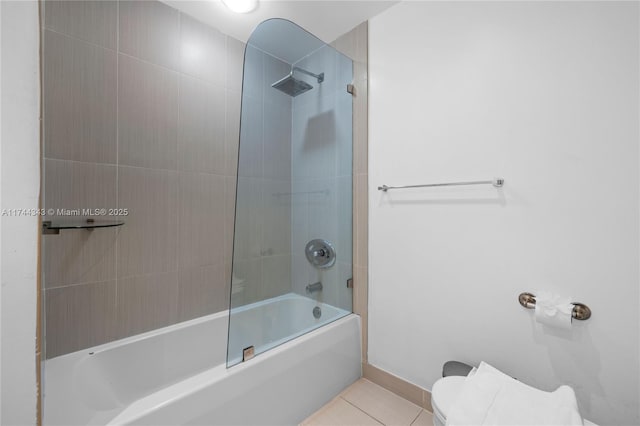 bathroom with tiled shower / bath, tile patterned floors, and toilet