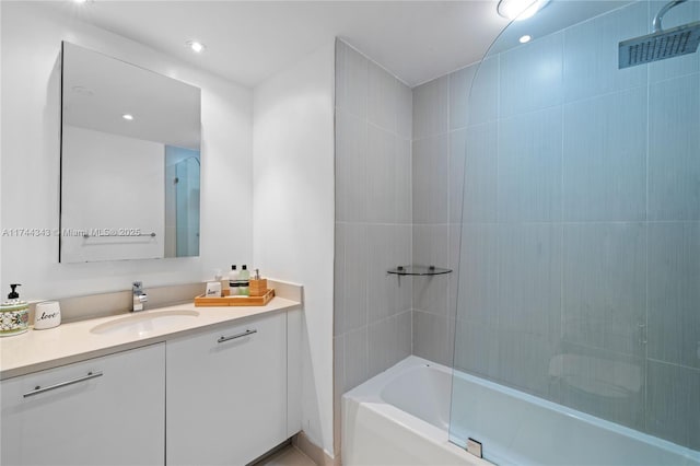 bathroom with tiled shower / bath and vanity