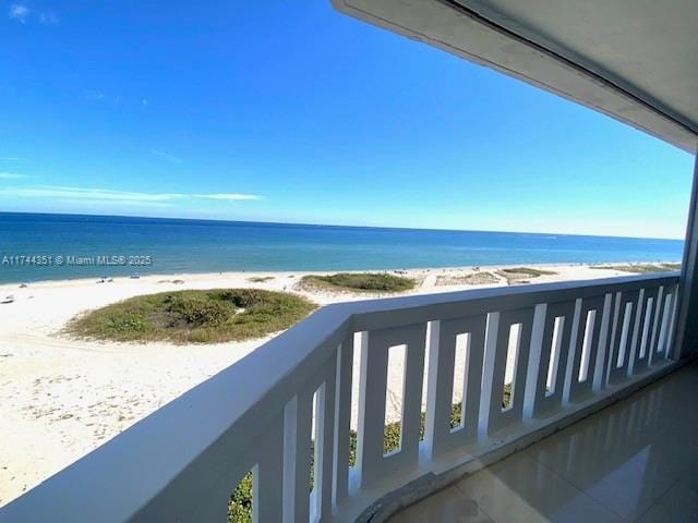 balcony featuring a water view and a view of the beach