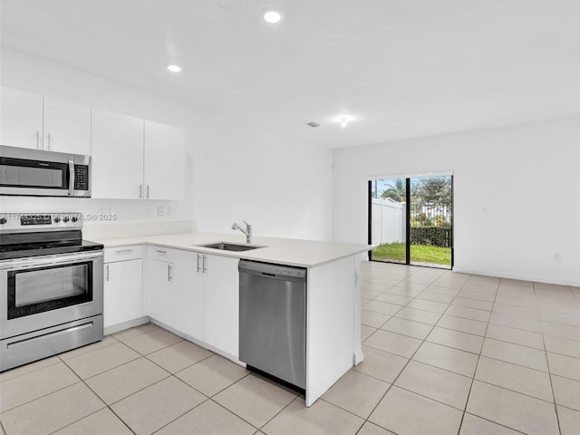 kitchen featuring white cabinetry, sink, light tile patterned floors, kitchen peninsula, and stainless steel appliances