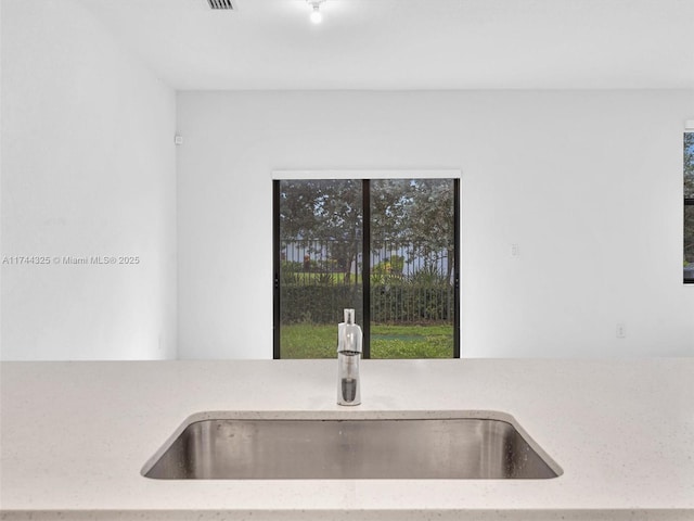 room details featuring light stone counters and sink