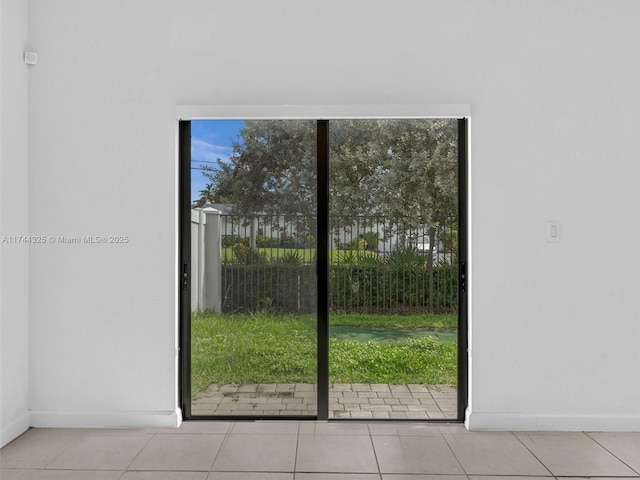 doorway with a healthy amount of sunlight and light tile patterned floors