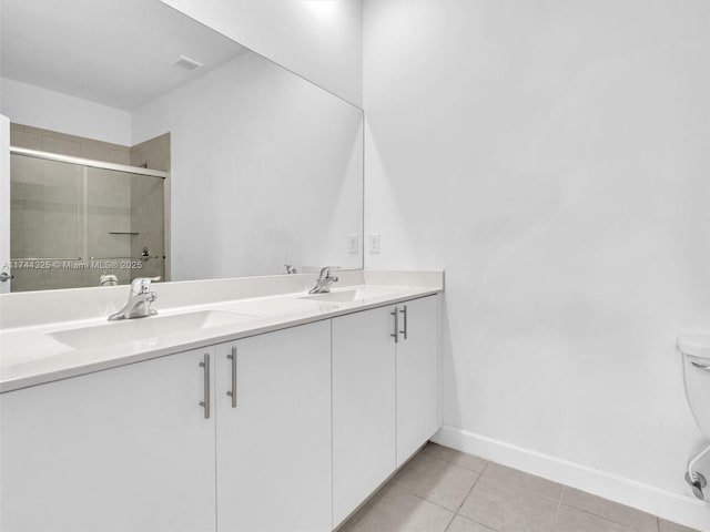 bathroom with tile patterned floors, toilet, an enclosed shower, and vanity