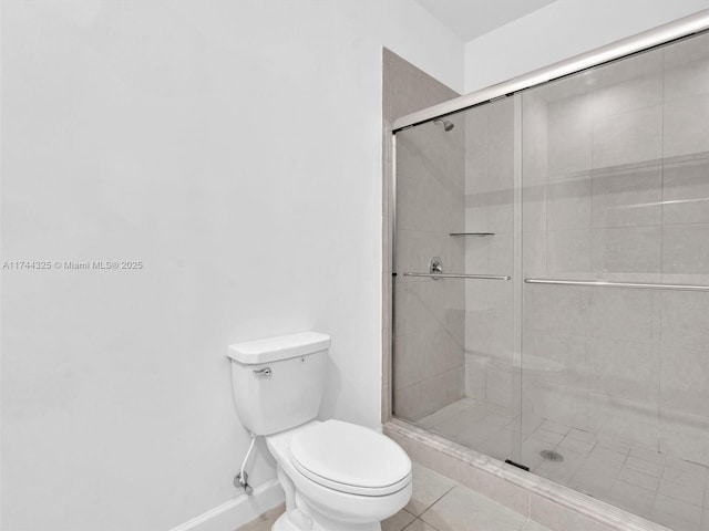 bathroom featuring tile patterned floors, toilet, and an enclosed shower