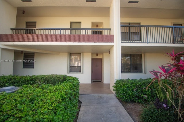 view of exterior entry featuring a balcony