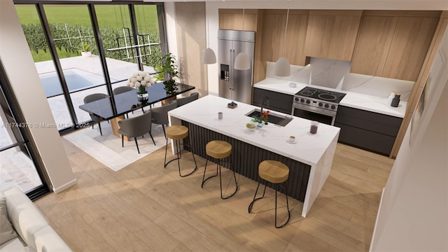 kitchen with modern cabinets, a sink, high end appliances, and a breakfast bar area