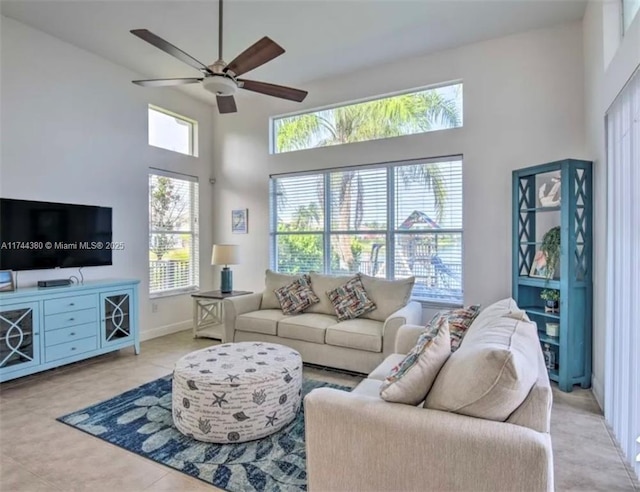 living room with light tile patterned flooring, a towering ceiling, and ceiling fan