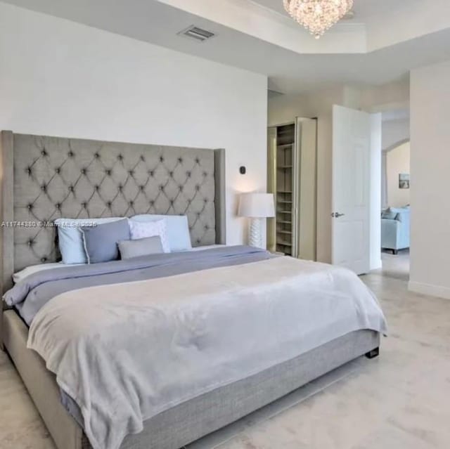 bedroom featuring a raised ceiling and a notable chandelier